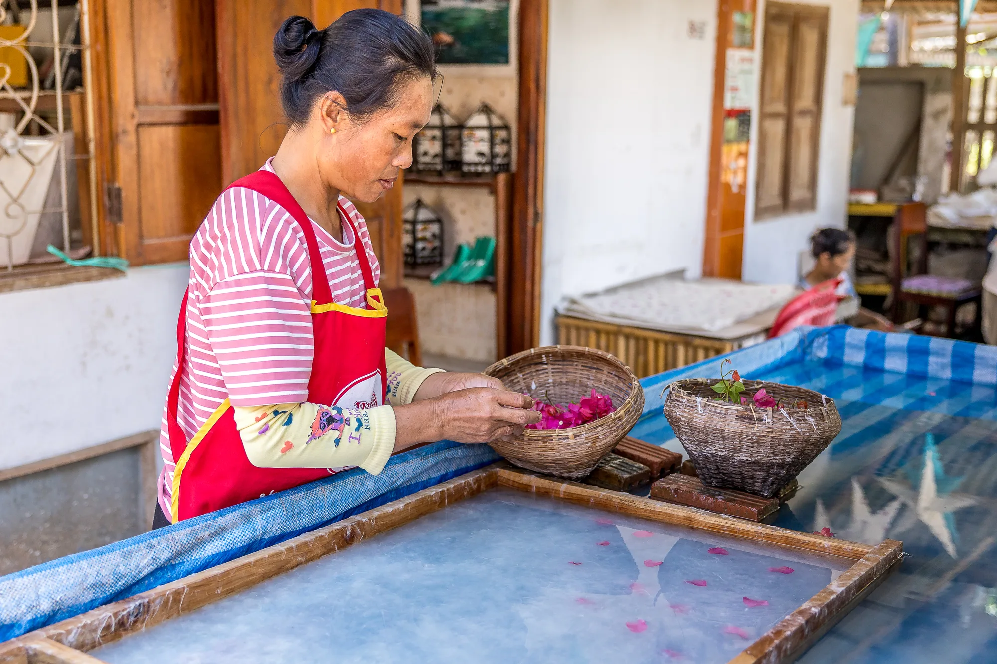 Artisan handcrafting paper with dried petals