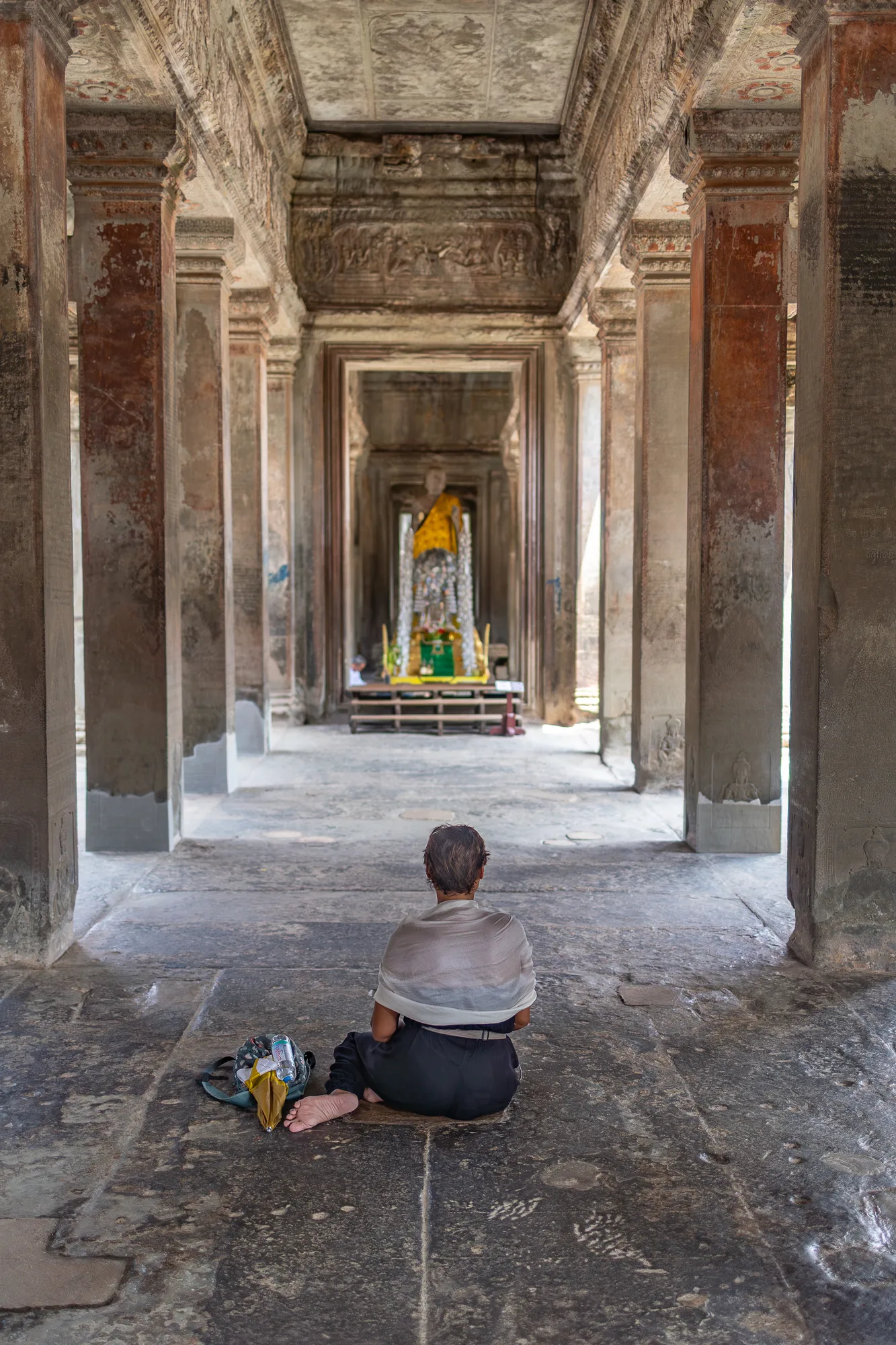 Devotee offering incense and prayer at Angkor temple