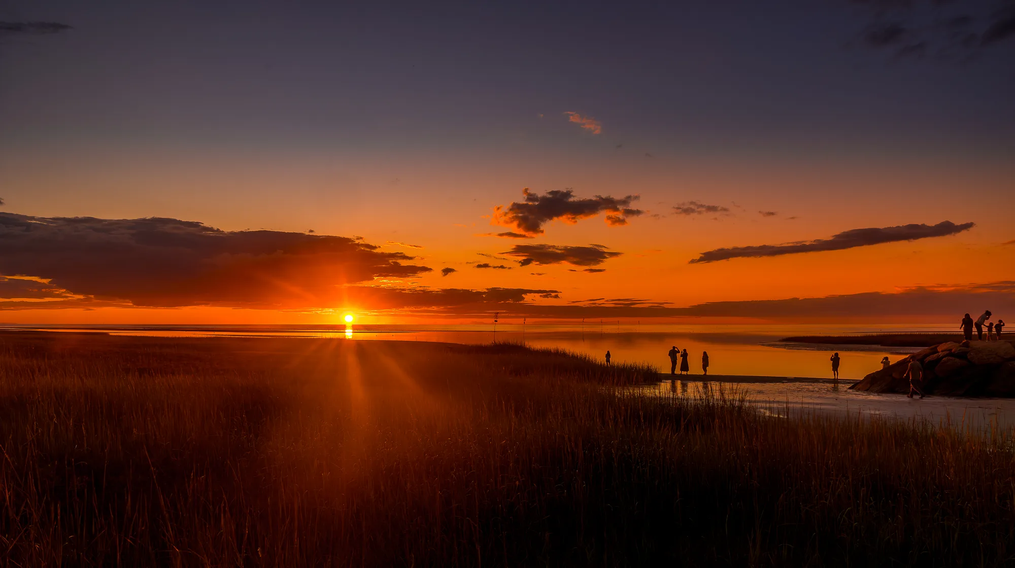 Pier stretching into evening ocean horizon