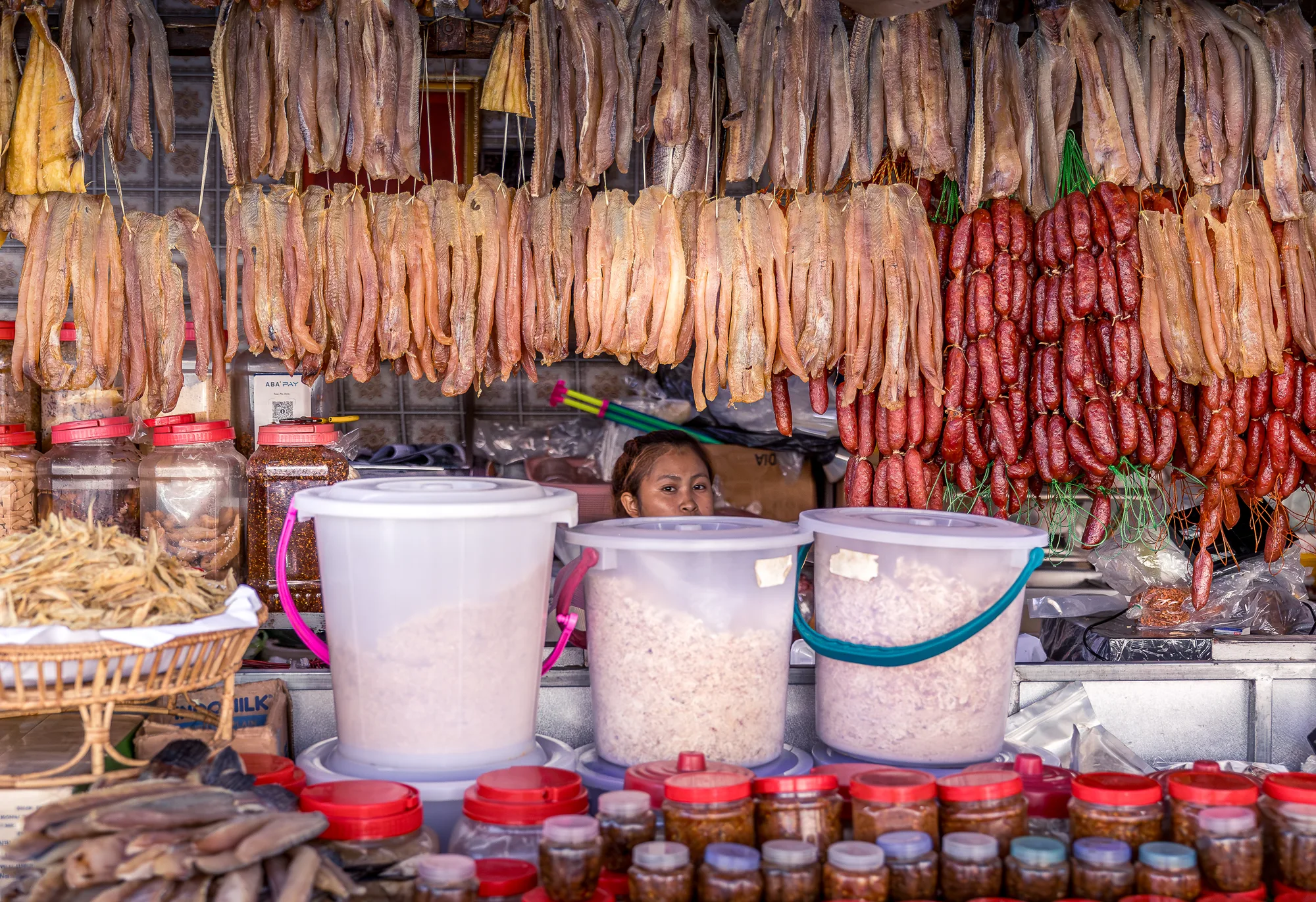Market seller glancing between stalls at dawn